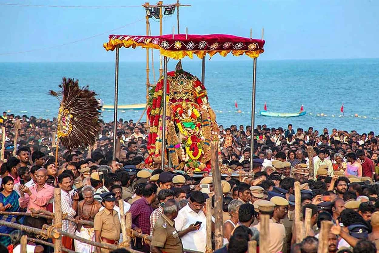 Decorated Murugan procession surrounded by devotees beside the Tiruchendur seashore